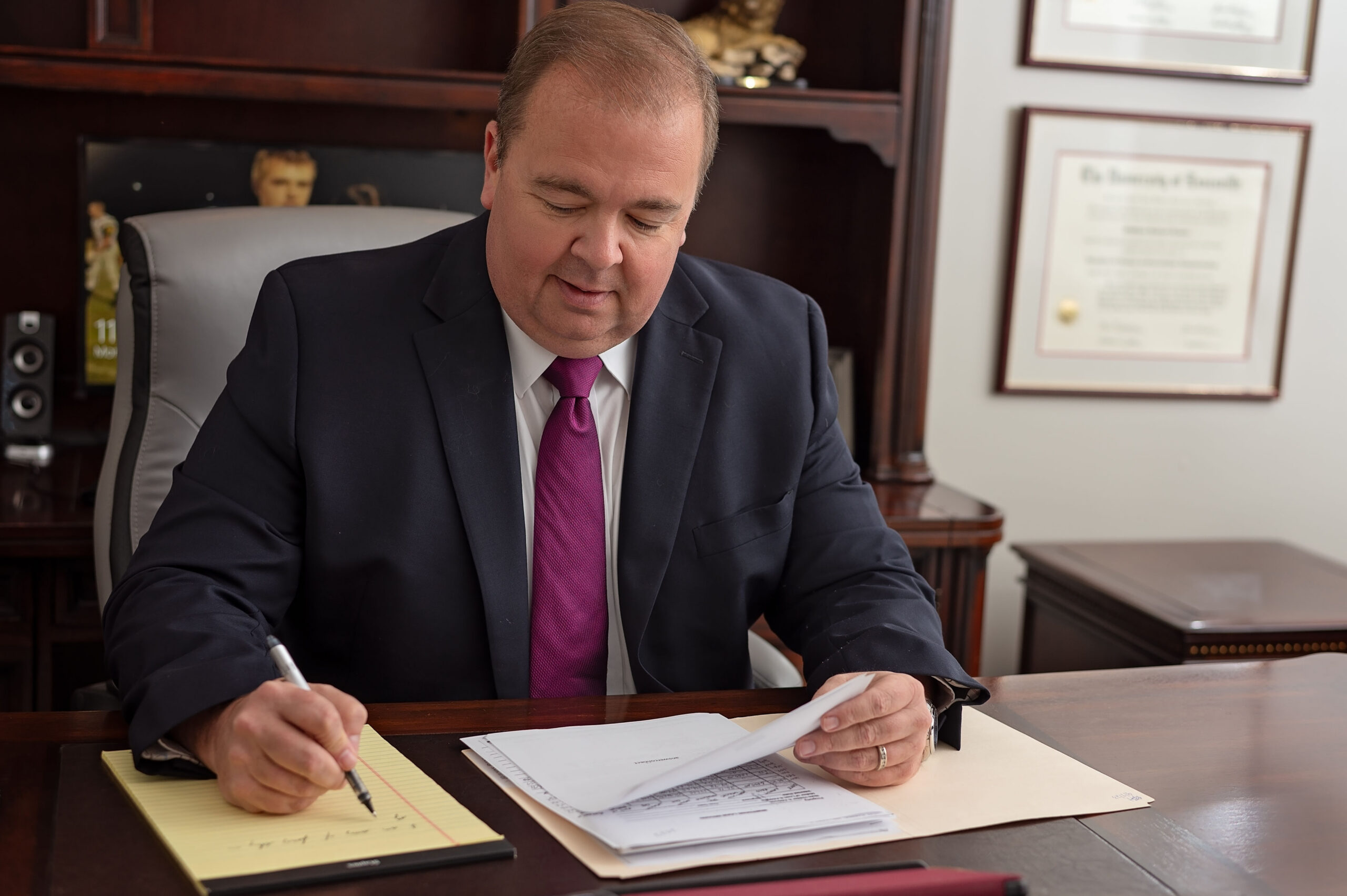Attorney Matthew Lemme in Louisville and Indiana sitting at his desk and reviewing a case file.